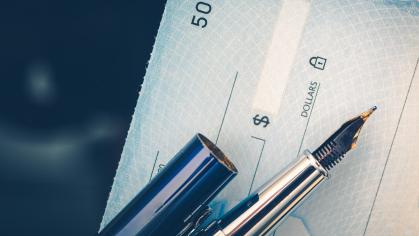 Picture of a bank check and a pen