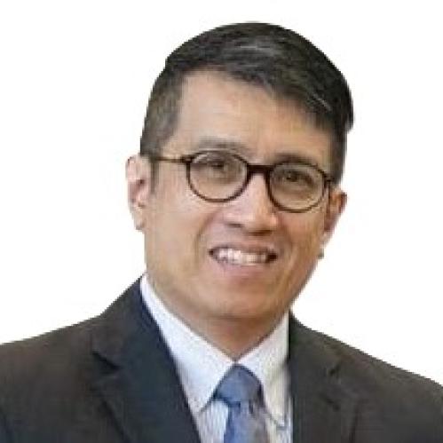 Headshot of Eduardo Valenzuela wearing glassing, a dark grey suit, and a blue tie.