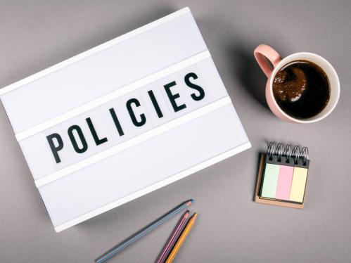 Policies. Text in light box. Pink coffee mug on gray background