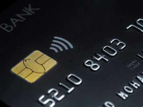 closeup of contactless symbol on a black credit card.
