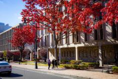 Conklin Hall Building, shot from street view, in front of a red-leafed tree.